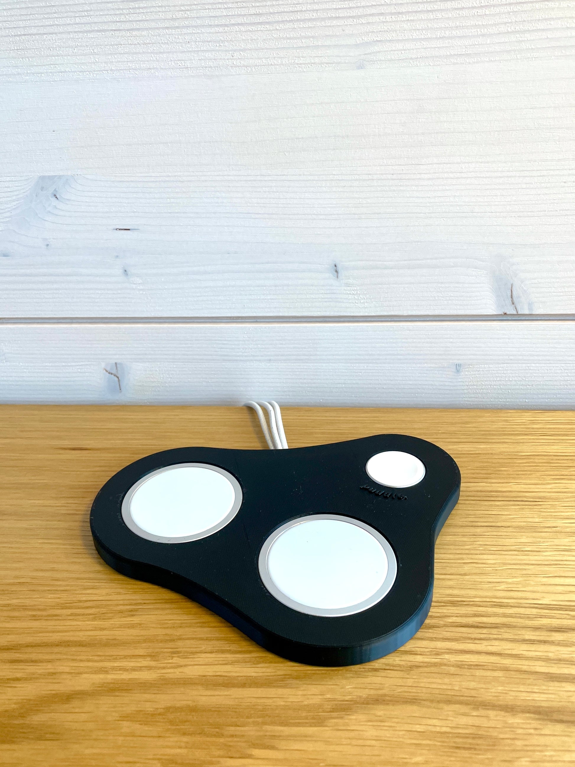 Siisti musta Puddle III MagSafe-teline Apple tuotteille, kolmella latauspaikalla