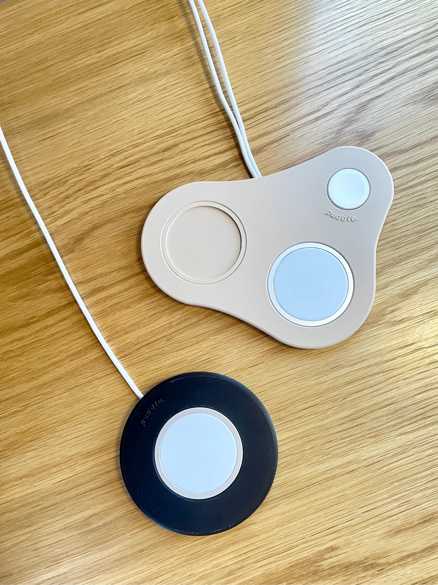 Musta Puddle kännykkäteline iPhonelle ja beige MagSafe laturinteline iPhonelle, AirPod-kotelolle sekä Apple Watchille